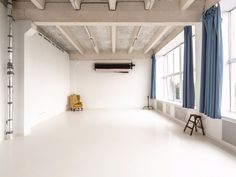 an empty room with blue drapes and white walls is seen in this image from the front