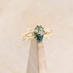 a gold ring with a green stone on top