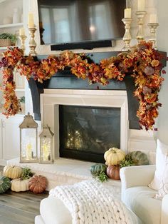 a living room decorated with fall foliage and candles