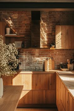 a kitchen with brick walls and wooden cabinets is pictured in this image, the sun shines through the windows