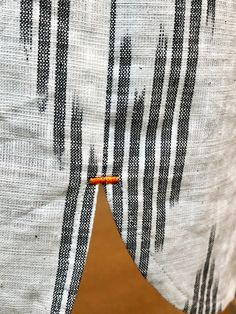 a close up of a piece of cloth with an orange button on it's end