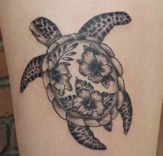 a black and white tattoo of a turtle with flowers