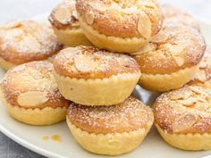 a white plate topped with mini pies covered in powdered sugar