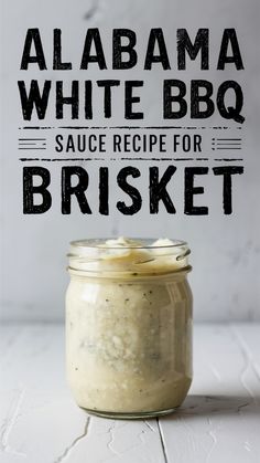 a jar filled with white bbq sauce sitting on top of a table