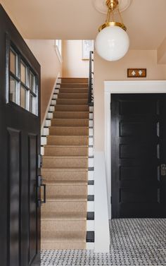 an entryway with stairs leading up to the door and light fixture on the ceiling