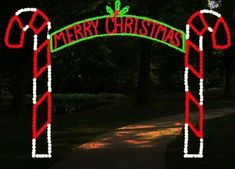 a lighted christmas arch with candy canes on it and the words merry christmas written in large letters