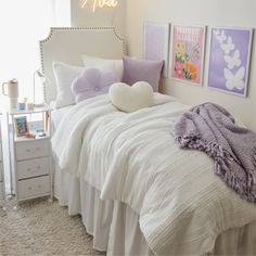 a white bed topped with pillows and blankets