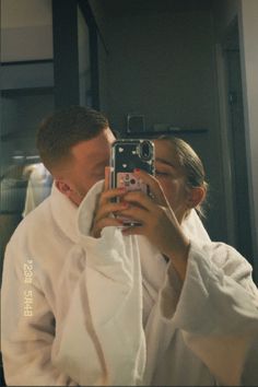 a man and woman taking a selfie in front of a mirror