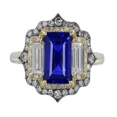 METAL SPECIFICATIONS Two Tone Gold 14K STONE SPECIFICATIONS Stone Name : Blue Sapphire and Diamond Stone Cut : Emerald, Baguette, and Round Stone Details : There is one emerald cut sapphire approx. 4.75 carats (Approx. Size 11 x 6 mm), two baguette diamonds approx. 0.25 carats each (Approx. Size 4.7 x 2.3 mm) and approx. 1.50 carats of round diamonds on the sides. Natural earth-mined stones. Color : F/G Clarity : VS1/VVS1 Quality of Sapphire : AAA Total : Approx. 6.75 Carats RING SPECIFICATIONS Blue Sapphire Diamond Ring, Baguette Diamonds, Blue Sapphire Diamond, Sapphire Diamond Ring, Natural Earth, Stone Cuts, Baguette Diamond, Sapphire Diamond, Diamond Stone