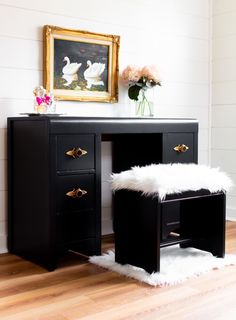 a black desk with two drawers and a white fur rug on the floor next to it