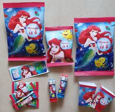 the little mermaid party supplies are laid out on top of each other, including toothpaste and candy