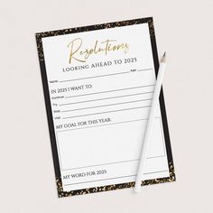 a black and white appointment card next to a pencil on top of a paper with gold foil