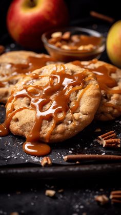 an apple pie with caramel drizzle on it and some cinnamon sticks next to it