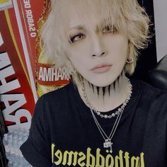 a woman with short blonde hair and piercings wearing a black shirt