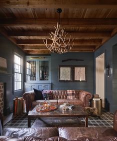 a living room filled with furniture and a chandelier hanging over the top of it