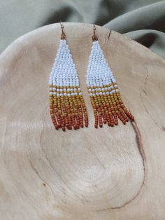 Handcrafted seed bead danglers; modeled after the snow dusted red rock in Sedona. White, mustard yellow, and rust with silver findings. Each pair is made with over 200 glass beads and woven with strong, braided thread. Approximately 2.25 inches long. Please care for your earrings, store them flat or hung when not being worn. Artisan White Beaded Earrings With Dangling Beads, White Artisan Beaded Dangle Earrings, White Unique Earrings With Dangling Beads, Adjustable Orange Tiny Beads Earrings, Artisan White Beaded Earrings With Colorful Beads, White Artisan Beaded Earrings With Colorful Beads, White Tiny Beads Earrings For Festivals, Artisan White Beaded Earrings, White Artisan Beaded Earrings