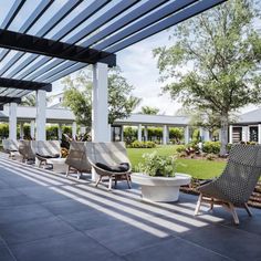 an outdoor seating area with chairs and potted plants