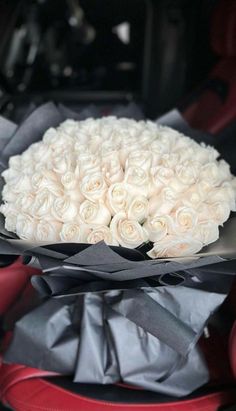 a bouquet of white roses sitting in the back of a car