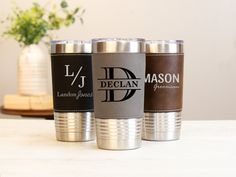 three personalized stainless steel tumblers sitting on a table