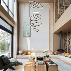 a living room filled with lots of furniture next to a large glass window covered wall