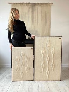 a woman standing next to two pieces of fabric