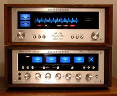 two old fashioned stereo equipment sitting on top of a wooden table next to each other