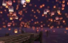 many lanterns are floating in the air over water