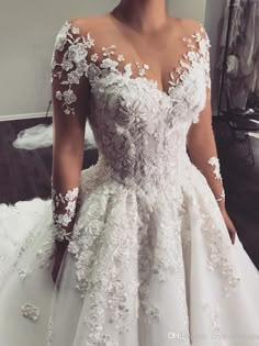 a woman in a white wedding dress standing next to a mirror