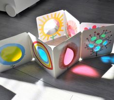 four brightly colored boxes sitting on top of a wooden floor