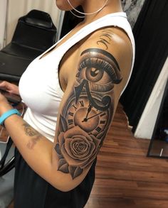 a woman with a clock and rose tattoo on her arm is looking at the camera