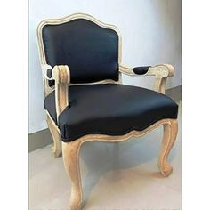 an antique chair with black leather upholstered on the back