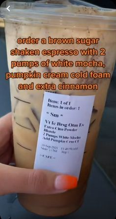 a person holding up a drink with a card in it's hand that says order a brown sugar shaker epress with 2 pumps of white mocha, pumpkin cream cold foam and extra cinnamon