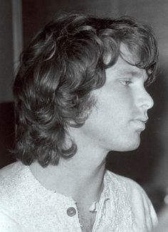 black and white photograph of a man with curly hair looking off into the distance,