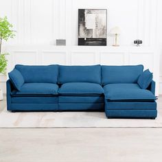 a living room with a blue couch and white rugs on the floor in front of a wall