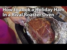 someone is cooking a ham in a roaster oven and it's wrapped in foil