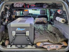 the back end of a van with an open trunk and bed in it's cargo area