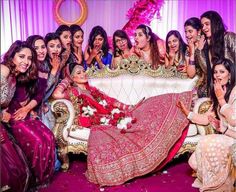 a group of women posing for a photo in front of a couch with flowers on it