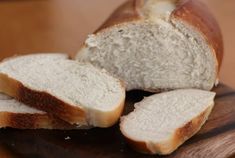 two loaves of bread sitting on top of a wooden cutting board