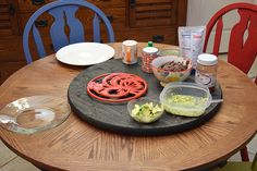 a wooden table topped with plates and bowls filled with food next to plastic containers on top of it