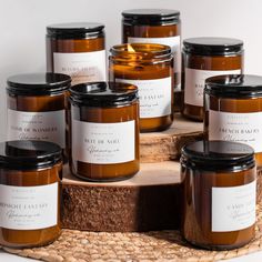 several jars of candles sitting on top of a wooden tray