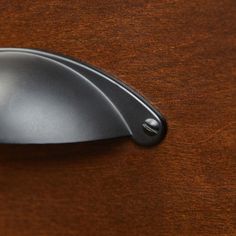 a close up of a computer mouse on a wooden surface with the top edge missing