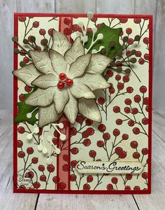 a christmas card with poinsettis and holly on the front, in red and white