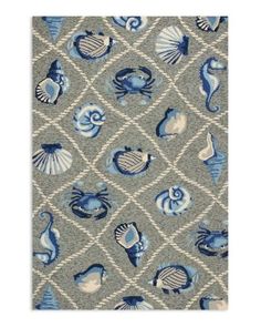 an area rug with blue and white sea animals on the side, in front of a gray background