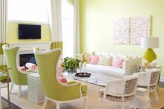 a living room with green walls and white furniture in the center, along with yellow curtains