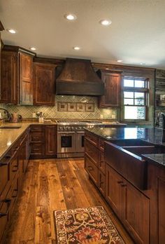 a large kitchen with wooden floors and granite counter tops, along with an area rug on the hardwood flooring