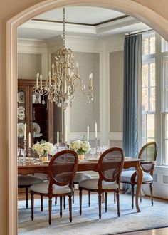 a dining room table with chairs and chandelier