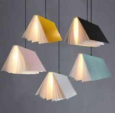 five lamps hanging from the ceiling in different shades of white, blue, yellow and black