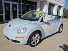 a white car parked in front of a building with a yellow tag on it's windshield