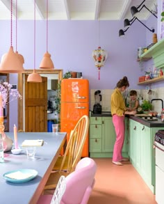 two women are in the kitchen preparing food for someone to eat at their dinner table