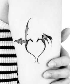 a woman's arm with a bat tattoo on it